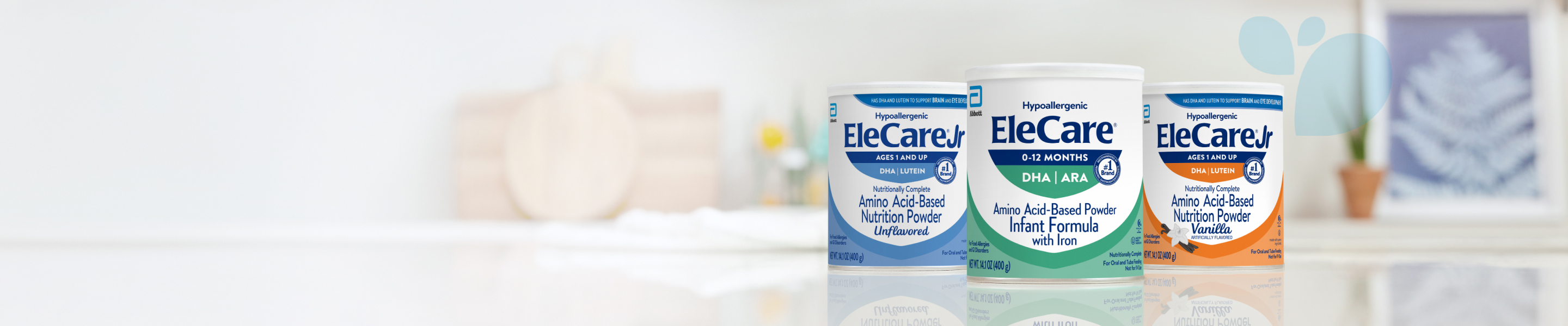 Cans of EleCare Jr Unflavored, EleCare Infant Formula, and EleCare Jr Vanilla sitting on a kitchen counter.